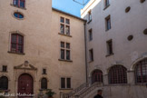 Château des Cauvet <br> La cour carrée est délimitée par quatre ailes aménagées ou bâties par les barons puis marquis de Covet. Elles constituent un palais urbain organisé autour d'un quadrilatère parfait. L'aile ouest présente des caractéristiques probablement du XVIe siècle comme les fenêtres à croisée, ainsi que des embellissements du XVIIe comme le portail à fronton brisé ordonné en 1605 par Jean-Baptiste Ier de Covet.