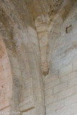 Saint-Trinit.<br> Celui du Nord-Ouest figure un atlante, petit personnage à genoux, tête, recroquevillé sur lui-même, fléchissant les jambes sur lesquelles il s’appuie et qui de ses bras supporte le poids d’une voûte.