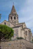 Eglise Saint Andéol. <br> Vue du Sud Est, on apprécie la progression des élévations jusqu’aux différents étages du clocher. L'édifice est remarquable par son chevet, son transept saillant, sa puissante tour lanterne élevée dans la deuxième moitié du xiie siècle, surmontée plus tard d'une flèche.