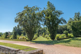 Le château de Cormatin. <br> Le Parterre
Depuis l’Antiquité, c’est une image du Paradis terrestre. Il est carré car la Terre est liée au chiffre 4. (4 éléments, 4 âges de la vie, 4 saisons, etc.)
Deux allées le divisent en 4 et se croisent au centre. Elles sont axées sur les 4 points cardinaux.
L’allée Nord-Sud représente les saisons et la vie collective.
L’allée Est-Ouest, qui évoque la journée et la vie individuelle, commence par une coquille à l’est (la naissance) et se termine à l’Ouest par la porte de la volière (la mort et le paradis céleste). Au centre du parterre, un bassin unit dans sa forme le carré et le cercle. Au fond du parterre, deux copies de statues antiques figurent Adam (à l’Est, puisque crée en premier) et Eve. Le couple humain encadre un hémicycle situé exactement “sous