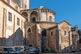 Saint-Philibert de Tournus.<br> Le chevet de l’église. Les chapelles ont des contreforts en saillie et des corniches à modillons. Les murs des parties basses du chevet montrent un appareil à petits moellons assemblés en opus spicatum. Il y a également quelques réemplois de fragments de claustra qui proviennent peut-être de la crypte carolingienne. La partie haute du chevet montre des arcs de contrefortage dans le chœur et des arcatures avec contreforts-colonnes et chapiteaux dans l’abside. Remarquons également le décor mural en opus sectile rouge et blanc sous les arcatures.