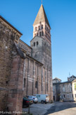 Saint-Philibert de Tournus.<br> sous le clocher, le narthex, moins large et légèrement plus élevé que la nef, possède des murs latéraux qui reprennent le style lombard de la façade. Deux étages de baies et un étage intermédiaire de meurtrières s’inscrivent entre des pilastres verticaux des bandes lombardes. La maçonnerie est en petit appareil ocre avec des rangs de moyen appareil blanc. Une frise en dents de scie se trouve entre les fenêtres hautes et la corniche de la chapelle de l’étage. Les murs de la nef sont beaucoup plus sobres. Les cinq travées sont flanquées de contreforts plats entourant les fenêtres hautes. Les fenêtres des bas-côtés ont été agrandies et ne sont plus d’origine, d’autres ont été remplacées par les chapelles gothiques du côté nord.