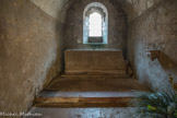 Saint-Philibert de Tournus. La crypte<br> Ces chapelles sont de plan rectangulaire, à chevet plat, et voûtées en berceau. Elles sont éclairées chacune par une fenêtre axiale. La chapelle axiale renferme aujourd'hui le sarcophage attribué à Valérien, martyr du IIe siècle, dont les reliques ont été détruites par les Protestants au XVIe siècle. Ce sarcophage ne comporte aucune inscription ni décoration. Le couvercle manque.