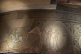 Saint-Philibert de Tournus. Le déambulatoire<br> En France, très peu de mosaïques ont été conservées en place pour cette période. Les thèmes du calendrier et du zodiaque, qui représentent le temps de Dieu à travers le cycle cosmique, celui de la nature et celui des travaux des hommes, en illustraient pourtant d’autres au XIIe siècle. Les tesselles sont taillées dans des calcaires de provenance locale, gris-beiges, roses ou noirs pour l'essentiel. Mais on note aussi des éléments de marbre, blancs ou bleutés, et quelques fragments de roches d'importation très colorées, sans doute récupérés de placages antiques - ainsi que des morceaux de terre cuite. On peut distinguer les étapes successives du travail des mosaïstes, à des lignes de césure qui marquent les différents mortiers de préparation. Style et technique relèvent une influence antique, peut-être relayée par des modèles italiens