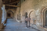 Saint-Philibert de Tournus. Le Cloître Saint-Ardain.<br> La galerie est du cloître, moderne, a été reconstruite pendant la grande restauration. A droite, la salle capitulaire. Entre les baies et la porte gothique ont été mis au jour les vestiges de la façade de l’ancienne salle capitulaire du 12e siècle. Il s’agit de deux arcades en plein cintre avec colonnettes et quelques chapiteaux sculptés de feuillages et de deux oiseaux affrontés.