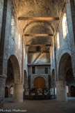Saint-Philibert de Tournus. La Chapelle Saint-Michel<br> L’espace d’une hauteur considérable est voûté en pierre, marquant l’architecture savante, reprise à Chapaize. La voûte en berceau, dont l’appareil est remarquable, repose sur des arcs doubleaux. Elle est supportée par quatre tirants en bois de chêne, reliés à des ancres métalliques, assurant la stabilité de la construction dès l’origine. On remarque des corniches à modillons en haut des murs intérieurs.