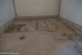 Cluny. <br> Ces vestiges appartiennent au chœur de la deuxième église abbatiale, appelée Cluny II et consacrée en 981.
La dalle rectangulaire supportait un autel qui abritait l’urne avec les reliques des saints apôtres Pierre et Paul. Rapportées d’Italie par l’abbé Mayeul dans la deuxième moitié du Xe siècle, leur présence a fait de Cluny un lieu de pèlerinage important.
Dans les quatre trous aux angles de la dalle s’inséraient les colonnes d’un ciborium, un baldaquin qui signalait l’importance de l’autel du sanctuaire. C’est pourquoi le chœur de Cluny II a été conservé jusqu’au XVIIIe siècle, sous l’appellation de chapelle Saint- Pierre-le-Vieil. Le chevet et le chœur ont été plusieurs fois remaniés entre le Xe et le début du XIIe siècle. Au départ, l'église présentait des caractéristiques carolingiennes : à trois vaisseaux, avec des murs de séparation entre chacun d’eux, et un chœur surélevé au-dessus d’une crypte à abside. Dans son dernier état médiéval, l’espace du chœur est ouvert et situé au même niveau que la nef et le transept ; le chevet présente trois absides, des caractéristiques de l'architecture romane appliquées dans d’autres édifices  clunisiens de la même époque.