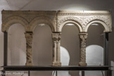 Cluny. <br> Claires-voies. Maison du 7, petite rue Lamartine.
Cette maison romane comportait une claire-voie à chacun de ses étages. Elles présentaient une alternance de colonnettes à fût orné et à fût lisse.
Colonnette torsadée, une bande sur deux est ornée de perles. Le chapiteau est décoré de volutes et de feuilles grasses.
Colonnette jumelée. La base est ornée d’une frise de feuilles d’eau. Le chapiteau est décoré de rinceaux de feuillages.
Colonnette à rinceaux de feuillages et oves (motif en forme d’œuf) répartis en cinq bandes verticales. Le chapiteau est orné de feuillages parfaitement symétriques.
Les arcades du linteaude droite sont soulignées d’une bande de petites fleurs à trois pétales. Une fleur à larges pétales orne l’écoinçon central et des demi-fleurs figurent sur les deux autres écoinçons.