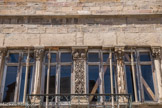 Cluny. <br> Ce niveau est ouvert sur l’extérieur par la claire-voie, véritable décor de théâtre par lequel les habitants se mettaient en scène pour observer la rue. L’importance des décors sculptés et peints permettait de montrer sa richesse aux passants.  Baies rectangulaires avec colonnettes, pilastres décorés et chapiteaux à dragons et oiseaux.