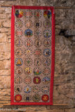 Cluny. <br> Les bannières ont aussi pour but d’évoquer le rayonnement de Cluny dans l’Occident médiéval, avec ses plus de 1500 dépendances.
Chaque bannière rassemble 40 carrés brodés de motifs originaux, spécialement dessinée, inscrit dans une rosace. L’assemblage forme carrelage à l’image des carrelages médiévaux.