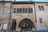 Cluny. <br> Considérée comme l’archétype de la maison romane au Moyen Âge, la maison Du Puits des Pénitents annonce en façade la polyvalence de son programme : au rez-de-chaussée la très vaste arcade donne accès aux activités professionnelles, tandis que la porte s'ouvre sur un escalier conduisant aux logis de l'étage. Celui sur rue, au premier étage, est abondamment éclairé et ventilé par une superbe suite de baies appelée claire-voie. Le contraste est saisissant entre les deux niveaux, la claire-voie s'arrogeant l'essentiel du décor sculpté, autrefois peint de vives couleurs. La composition romane de la façade du n°23 présentait au rez-de-chaussée, une grande baie rectangulaire, dont le linteau monolithe est conservé.
Située dans la perspective montante, à l'arrière du Puits dit “des Pénitente ou du Petit Saint-Jean”, une des plus belles maisons romanes présentait deux arcades au rez-de-chaussée et une très vaste claire-voie de 10 baies à l’étage, soulignée par une frise sculptée. Il faut souligner que cet édifice est la seule maison romane dont on ait identifiée les propriétaires : en 1248, elle appartenait à la famille du Bois, une des plus connues de la grande bourgeoisie clunisoise.