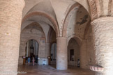 Saint-Philibert de Tournus. Le narthex <br>  L’église carolingienne fut restaurée en 970 par l’abbé Etienne. Elle possédait alors une crypte voûtée sous un chœur et une nef sous charpente. Vesr 1030, le monastère est agrandi par l’abbé Ardain, qui ajoute un grand narthex à l’église et qui reconstruit le cloître. Le chantier de l’église ne cesse pas : l’abbé Pierre I achève les voûtes singulières de la nef à la fin du 11e siècle et au début du 12e siècle le transept, le chœur et les clochers sont reconstruits dans le nouveau style roman. La splendeur de l’église se rapproche de celle de la grande abbaye voisine de Cluny, dont l'abbaye de Tournus reste indépendante. L’église est à nouveau consacrée en 1120 par le pape Calixte II. La translation des reliques de Saint-Ardain dans l’église en 1140 marque le dernier grand événement de la période romane. C'est la grande époque de l'abbaye, qui ne dépendait que du Pape et du Roi de France, et dont les abbés furent seigneurs de la ville et de vastes domaines en Mâconnais et bien au delà.