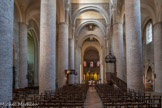 Saint-Philibert de Tournus. La nef<br> La grande nef, autre chef-d’œuvre de l’abbatiale, est une vaste salle haute et lumineuse. Son architecture unique est l’une des plus originales de l’école romane de Bourgogne. Les cinq travées ont été commencées au début du 11e siècle avec les hauts piliers ronds maçonnées, les grandes arcades et les murs en petit moellon calcaire. Les bas-côtés voûtés d’arêtes sur doubleaux et demi-colonnes sont de la même époque. Le décor de la nef est relativement modeste. Il n’y a pas de chapiteaux sculptés, à l’exception des baies géminées s’ouvrant sur la chapelle du narthex. Il y a quelques fresques romanes, probablement des vestiges d’un ensemble couvrant une grande partie de la nef.