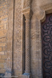 Le décor sculpté des colonnes et des voussures du portail est très riche : on y admire des feuillages, des hélices, des guirlandes, des billettes en damier, des feuilles d’acanthe et des perles. LChapiteau sculpté de branches raides.