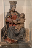 Vierge à l’Enfant tenant une grappe de raisin dite « Notre-Dame de Beaune ».
Pierre polychrome. XVIe siècle.
Provient d’une maison de Beaune démolie en 1901 Dépôt de la Société archéologique de Beaune, dépôt du Musée des Beaux-arts de Beaune en 1946 i lnv. D.46.10.1
La Vierge est la patronne de la ville de Beaune. La grappe l de raisin qu’elle tient avec l’Enfant évoque la place essentielle que tient le vin dans la religion chrétienne. Assimilé au sang du Christ dans la liturgie, le vin voit sa production et sa consommation fortement augmenter dès le début de l’époque médiévale. Les évêchés et les établissements monastiques possèdent un nombre important de vignobles. Produisant du vin pour le culte et pour répondre à leur devoir d’hospitalité, ces communautés religieuses ont joué un rôle déterminant dans le développement du vignoble et du parcellaire viticole bourguignons.