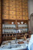balances et poids : pour peser tous les ingrédients nécessaires à la fabrication des médicaments. Pendant que certaines sœurs s'occupent des pauvres malades de l’hôpital, d’autres fabriquent les médicaments dans le magasin de la pharmacie.
Selon les indications du médecin ou du pharmacien, elles préparent les remèdes comme une recette de cuisine. Par exemple, pour confectionner des pilules :
elles pèsent les matières premières avec une balance à plateau ;
elles écrasent les produits dans le mortier avec le pilon ;
elles mélangent tous les ingrédients puis passent la pâte dans une douille
enfin elles coupent les pilules et les enrobent de sucre ou de réglisse pour masquer le goût souvent désagréable.