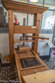 PRESSE DITE DE GUTENBERG
Johannes Gutenberg (vers 1400 - 3 février 1468) n’a pas inventé l’imprimerie mais un procédé mécanique d’impression qui permettait de multiplier rapidement et à moindre coût un certain nombre d’exemplaires d’un même livre.
L’ouvrier disposait l’encre sur la forme au moyen de balles en cuir rembourrées de crin et munies de poignées de bois. Ces balles étaient en peau de chien qui donnait un cuir très fin et qui était dépourvu de pores.