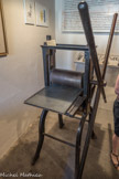 TAILLE DOUCE
La taille-douce désigne l’ensemble des procédés de gravure en creux plaque en métal.
La grande précision de dessin permise par cette technique l’a particulièrement destinée à la fabrication de billets de banques, de timbres-poste, de cartes d’état-major... Aujourd’hui, la technique d’impression se perpétue principalement à travers la réalisation d’estampes originales. Le procédé aurait été inventé, par un orfèvre, Thomas Finiguerra, en 1452, à Florence. Il aurait rempli avec du noir de fumée les tailles d’une plaque d’argent gravée pour obtenir une estampe.
Impression avec une presse taille-douce
L’artiste graveur réalise son dessin directement sur la plaque de métal, à 1’aide de burins ou de pointes sèches. Cette plaque est ensuite posée sur le plateau de la presse. Le taille-doucier encre sa plaque avec un rouleau ou un tampon en tissu. Tous les creux deviennent alors des réservoirs d’encre. Puis, avec une mousseline appelée tarlatane, l’artiste enlève le surplus d’encre ; il ne reste de l’encre que dans les tailles.
Le papier utilisé pour l’impression doit être assez épais. Il sera légèrement humidifié pour lui donner de la souplesse et pour lui permettre d’aller puiser l’encre jusqu’au fond des tailles. Le taille-doucier pose alors sa feuille de papier sur la plaque de métal. Par une action mécanique, le plateau se déplace et fait passer la plaque et la feuille sous le cylindre de la presse. Cette opération permet l’impression du papier. L’épreuve obtenue, encore humide, est mise à sécher pendant 48 heures entre des buvards et des cartons épais.