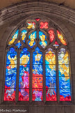 Dans la partie inférieure, le feu de l'enfer et, vaincus par les douze Anges de Dieu et précipités dans la géhenne, les chevaux évoquant la famine, la mort, la souffrance... Les poissons symbolisent le Peuple de Dieu qui monte vers l'Agneau, image du Christ, mort sur la croix et ressuscité pour le salut du monde. En bas, un bélier, préfiguration du sacrifice et de la mort rédemptrice du Christ, évoque avec le buisson ardent notre montée vers l'Agneau de Dieu à la croix victorieuse, figure centrale du vitrail.