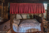 et le lit à baldaquin aux abords du foyer,