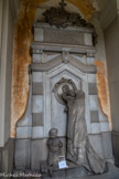 Cimetière monumental de Staglieno. <br> Tombe Casella, 1884, sculpteur Benetti. Une veuve avec ses deux enfants visite l’effigie du père.