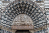 Cathédrale San Lorenzo <br> Dans le portail du centre, le Christ bénissant, portant un livre doté d'une inscription, est entouré d'une mandorle ; il semble s'éveiller du tombeau, dont on voit la couche derrière lui. Le reste de ce niveau est agrémenté des quatre animaux de l'Apocalypse dans lesquels la tradition chrétienne reconnaît habituellement les quatre Évangélistes.

Dans le niveau inférieur, une frise horizontale présente le martyre de saint Laurent, sur un gril entouré de deux bourreaux qui attisent les flammes avec des soufflets. À gauche, on reconnaît l'empereur, barbu et qui d'un doigt impérieux commande l'exécution.