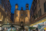 Place Banchi. l'Eglise San Pietro in Banchi, est un exemple unique de bâtiment religieux construit au-dessus de commerces; un étrange mélange entre sacré et profane. L'église fut construite grâce aux produits dérivant de la vente des espaces consacrés à l'exercice du commerce, et était le fruit d' un compromis entre la volonté de la famille Lomellino – qui souhaitait destiner ces espaces à un usage commercial – et le désir de la population de construire une église afin de répondre à un vœu pour la cessation de la peste de 1579, comme le cite l’épigraphe inscrit sur la toile de la Vierge.