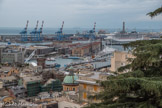Vue panoramique de Gênes vers le sud-ouest. Le bâtiment du coton et, derrière, à gauche, les portiques pour les containers et, à droite,  la Porte de la Lanterne.