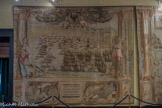 Villa del Principe. Palais d'Andrea Doria.<br> Salle du Naufrage. Les ébauches des scènes centrales de la bataille furent réalisées par Lazzaro Calvi tandis que les ébauches des figures allégoriques et des cadres furent réalisées par Luca Cambiaso. Les scènes de bataille sont entourées par de faux cadres architectoniques formés d’un soubassement avec une inscription et des colonnes sur lesquelles sont appuyées des figures féminines qui symbolisent les vertus indispensables pour obtenir la victoire et la célébrité. Toutes les tapisseries sont dominées au centre de la partie supérieure par l’aigle héraldique des Doria. La flotte chrétienne part de Messine à la fin de l’été de 1571 sous la conduite de Don Juan d’Autriche, enfant naturel de l’Empereur Charles V. Parmi les nombreuses enseignes chrétiennes décrites dans la tapisserie, on distingue en bas à gauche la Capitana nova de Giovanni Andrea I Doria, reconnaissable dans toutes les illustrations et caractérisée par la présence sur l’arrière du feu en forme de globe céleste, cadeau de sa femme Zenobia. La représentation de la scène principale est flanquée à gauche par l’allégorie de la Concorde identifiée par les attributs iconographiques du caducée et de la lyre et à droite par la Némésis, caractérisée par la présence d’un mètre et du frein offert par l’enfant.