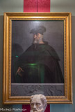 Villa del Principe. Palais d'Andrea Doria.<br> La salle de Psyché. Il s’agit du portrait le plus connu d’Andrea Doria, réalisé sur tableau par Sebastiano del Piombo en 1526 sur commission du Pape Clémente VII, pour célébrer la nomination de l’amiral de Gênes à commandant suprême de la flotte pontificale. Andrea est ici représenté à l’âge de soixante ans, avec un austère vêtement noir et la barrette d’amiral sur la tête. Sous la figure, l’on voit une frise à l’ancienne qui représente six trophées maritimes pris d’une décoration en marbre du Ier siècle avant Jésus Christ conservée au Musée Capitolin et qui probablement se réfèrent aux six galères offertes par le Pape. Au point de vue style, c’est un ouvrage d’une grande valeur. La modulation très fine des gris et des noirs fait ressortir de manière efficace les seuls éléments aux couleurs voyantes: le visage d’Andrea et la main indiquant les emblèmes de la frise.