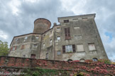 Château de Rocca Grimalda. <br> Dominant la vaste vallée de l’Orba et ainsi convoité pour sa position stratégique et facile à défendre, le château a été construit en plusieurs phases successives autour de la majestueuse tour de guet circulaire dès le début du XIIIe siècle. Faisant partie du fief du marquis de Monferrat, il a ensuite été transmis aux marquis de Gavi. Puis, en 1431, il a été donné à Jean Galeazzo Trotti, le capitaine des mercenaires du Duc de Milan. En 1570, le fief a été acquis par Baptiste Grimaldi, d’origine génoise. Sa famille est restée propriétaire du château pendant plus de 250 ans. Elle en finit la construction à la fin du XVIIIe siècle avec la majestueuse façade côté ouest, la Chapelle décorée à l’aide de trompe-l’œil et la réalisation du jardin suspendu, surplombant la vallée de l’Orba. La présence des Grimaldi, influente et durable, a provoqué le changement définitif du nom du village en “Rocca Grimalda”. Aujourd'hui, le château appartient à une grande famille d'anciennes origines de la Ligurie et du Piémont qui a restauré le jardin et le bâtiment, ce qui en fait une résidence confortable pour les propriétaires et leurs invités.