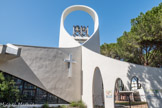 La Grande-Motte. <br> Le clocher de l'église de La Grande Motte accueille une cloche en provenance de Montagnac, petite commune de l'Hérault. Elle date du 17e siècle. On trouve plusieurs inscriptions et sceaux : une phrase tout d'abord, « mon ton appelle le peuple », mais aussi le blason du roi Henri IV. Enfin, on y trouve l'emblème de la ville de Nîmes arborant le palmier et le crocodile et la mention « col nem » (pour çofonia nemosus, littéralement « colonie de Nîmes »). Ces différents sceaux traduisent le déplacement, à plusieurs reprises, de la cloche jusqu'à son installation à La Grande Motte. Une seconde cloche, à droite, a été bénie et installée dans le clocher en octobre 2014 afin de commémorer les 40 ans de la création de la Grande-Motte.