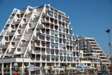 La Grande-Motte. <br>Le territoire actuel de la Grande-Motte est une ancienne partie de la commune de Mauguio ; à l'époque, ce territoire était une zone naturelle inhabitée car occupée par un marécage impropre à l'urbanisation. À partir des années 1960 et de la mission Racine, la Grande-Motte devient une station balnéaire créée ex nihilo. À la Grande-Motte, l'architecte Jean Balladur rompt avec la tradition de l'architecture pittoresque des villes balnéaires. Son projet  est très décrié à l'époque car, répondant à la démocratisation du tourisme de masse, un plan de desserte des plages en peigne, des façades perpendiculaires au littoral. Son œuvre est surtout marquée par les immeubles de type ziggourat rappelant les pyramides précolombiennes (Téotihuacan) et les architectures modernes du Brésil qu'il a visitées. L'objectif de ces pyramides à 60° est de fournir des points de vue différent à chaque habitant qui dispose de balcon et terrasse à chaque étage et de réaliser une transition douce entre le littoral et la chaîne montagneuse des Cévennes. Grâce à cette réalisation architecturale, la ville a reçu le label « Patrimoine du XXe siècle » le 19 janvier 2010. Immeuble Le Provence.