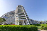 La Grande-Motte. <br> Jean Balladur souhaite que son architecture instaure un dialogue avec le paysage environnant. Les pyramides tronquées du Centre-Ville ont pour vocation de créer un relief sur un littoral par nature extrêmement plat. Il donne à La grande pyramide la forme inversée du Pic Saint Loup, montagne des Montpelliérains, pour la faire répondre à ce relief dominant l'arrière-pays. Vus depuis la mer, par temps clair, bâtiment et montagne s'épousent et se
complètent parfaitement.