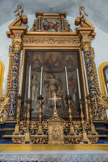Saint-Sauveur-sur-Tinée <br> Chapelle des pénitents blancs. L'architecture du retable de l'annonciation comporte, sur un triple gradin, deux colonnes à base droite et fût torsadé qu'habillent des rameaux fleuris et des pampres de vigne, flanquées d'ailerons habités d’angelots.