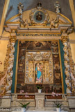 Saint-Sauveur-sur-Tinée <br> Retable du Rosaire. La périphérie du retable se compose de colonnes torsadées où courent des pampres de vigne et d'ailerons découpés en élégantes volutes frangées de feuillages tombant de la base d'un terme (torse et visage humains dépourvu de membres). Dans la niche centrale est placée une statue de facture industrielle moderne.