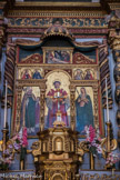Roure. <br> Le polyptyque, au-dessus du maître-autel, montre, dans son panneau central, St Laurent, portant la dalmatique, l’habit liturgique des diacres, avec son attribut, un gril. Né en Espagne (ou à Rome ?), archidiacre du pape St Sixte II et chargé des biens de l’Eglise, il est, selon la légende, supplicié sur un gril pour lui faire livrer les Livres Saints et les richesses dont il avait la garde mais qu’il avait distribuées aux pauvres sur ordre du pape. A ce double titre, il est considéré comme le patron des pauvres et des archivistes, Il fut l’un des martyrs les plus populaires de la chrétienté. Il est réputé guérir les brûlures et prévenir les incendies.