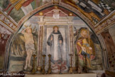 Chapelle Saint Sébastien de Roure. <br> le Christ crucifié étend ses bras sur Saint Sébastien à gauche, Saint Bernard de Menthon qui tient le diable enchaîné au centre, et Saint Roch tenant un bourdon de pèlerin et montrant la plaie de sa cuisse qui est un stigmate de la peste pour la guérison de laquelle on l’invoquait, à droite. Saint Sébastien et Saint Roch sont les Saints anti-pesteux.