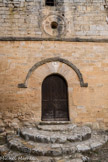 La chapelle Notre-Dame et son-prieuré. La porte en plein-cintre avec de larges claveaux, est surmontée d’un Christ sculpté bénissant de la main droite et tenant le Livre de la main gauche.