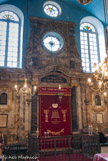 <center>La Synagogue</center>En haut, un édicule avec oculus dans une travée de pilastres cannelés cantonnée d'ailerons
