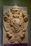 <center>Le château des ducs de Bretagne. </center> Moulage du projet de sculpture du blason du grand Gouvernement. Ce moulage a été réalisé dans le cadre de la restauration du monument, le blason ayant été martelé pendant la Révolution française sur l’initiative de la municipalité. Le blason est décoré d’un large cartouche portant les armes de la dynastie des Bourbons. L'écu, à gauche, présente les armes de la monarchie française depuis le 13e siècle.
À droite, les chaînes passées en croix, en sautoir et en orle, illustrent les armes de Navarre. Ces deux motifs sont associés depuis le règne de Henri IV. Le L de Louis XIV marque la présence de la 