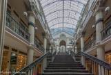 <center>Le Passage Pommeraye. </center> Premier niveau. Les trois niveaux de galeries sont soutenus par 16 colonnes cannelées et desservies par un large escalier équipé d'une magnifique rampe en ferronnerie fondue par VORUZ et de marches en bois travaillées par le menuisier LOTZ.