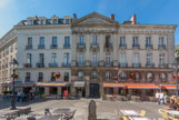 <center>La place du Bouffay. </center> Son petit marché couvert laisse mal supposer que s'y tenaient jadis les tournois, les foires, les processions ou les exécutions, de même qu'il faut deviner que la Loire passait à quelques mètres, du côté ouvert de la place. ici, bel immeuble du XVIIIe.