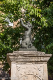 Son sommet est coiffé d’un angelot agenouillé sur une tortue, soufflant dans une corne et portant un coquillage en pendentif. Cette statue de bronze est la copie de l’original qui fût volé.