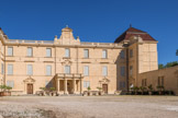 Le château de Castries. <br> Au XIXe siècle, Edmond-Eugène-Philippe-Hercule de La Croix (1787-1866) parvient à racheter une partie du domaine. Le corps principal du château est modifié : réduction des fenêtres, ajout d’un portique à colonnes, surélévation du pavillon Nord-Est. Le corps principal de 70 mètres de long, est encadré de 2 tours carrées dont les toitures ont été entièrement restaurées entre 1994 et 1999. Le corps central est flanqué de 2 ailes longues de 50 mètres. Il est précédé d'un portique où s'est niché un buste de Louis XIV.