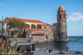 Collioure. <br> Église Notre-Dame-des-Anges. Située sur un ancien îlot ou l’ancienne église Sainte Marie dans la vieille ville, déjà partiellement détruite pendant la guerre de 1642 entre la France et l’Espagne, elle fut entièrement rasée en 1672 sur ordre de Vauban pour réaliser les Glacis du Château. Il faudra attendre 1684 pour que soit édifiée la nouvelle église qui s’appuie alors contre le phare. Entre-temps, Vauban ne veut plus de port à Collioure, il préfère la baie en eau profonde de Port-Vendres. Du fait, Collioure n'a plus besoin d'un phare. Il devient dès lors le clocher de l'église. Les pierres du clocher montrent les étapes de sa construction. Vers 1809, une décision municipale est prise pour le couvrir d'une coupole en s'inspirant d'un modèle originaire de Toscane. La galerie en brique extérieure sera rajoutée en 1725. Elle servira de latrines.