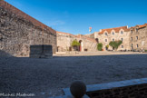 Le château royal. <br> La place d'armes. Un boulet en pierre et le puits.