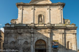 EGLISE SAINT GENIES (GENEST) <br> Au premier registre, on peut voir deux colonnes engagées, encadrant le porte, quatre pilastres et quatre niches qui ont dues contenir des statues. Au-dessus, des triglyphes et des métopes. Au second regristre, quatre pilastres engagés surmontés de chapiteaux ioniques, encadrent la statue de Gérard Tenque, sculptée ens 1869 par un maçon de Martigues, Nazaire Bernard. Le tout est surmonté par un tympan en arc de cercle, décoré de denticules.