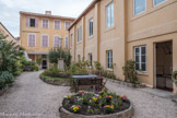 Foyer Jean-François Régis. <br> Ancien jardin du 44, avec le bâtiment central construit en 1900. Au fond, la maison de 1784. Le 18 septembre 1784 Dame Carbonel, veuve Long, achète dans le quartier des Réformés, un terrain 