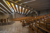 Le Sanctuaire de Notre-Dame de Vie de Venasque. <br> Chapelle Sainte Emérentienne. A l’opposé, l’autre mur de pierre se déplie sous les coques et contribue à donner l’allure d’un grand coquillage ouvert à cet espace harmonieux qui épouse la pente de la colline. Le maître d’œuvre a réussi, en mariant pierre et béton, sobriété et audace, à créer un lieu de prière qui trouve son plein achèvement lors des célébrations liturgiques.